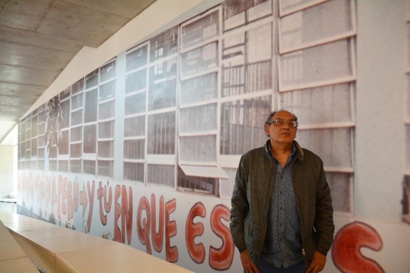El artista peruano Herbert Rodríguez frente a la imagen de su obra en el LUM